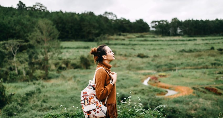 woman standing in the middle of grass field